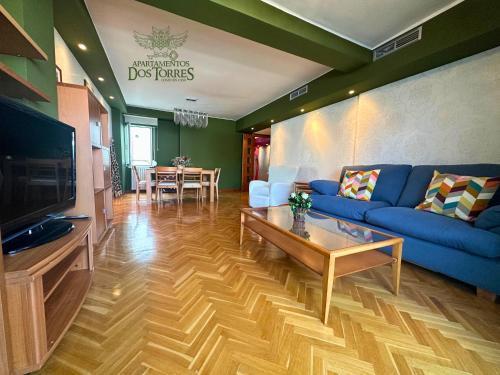 a living room with a blue couch and a table at Dos Torres Ático - Solárium Privado en Calle Alfonso I in Zaragoza