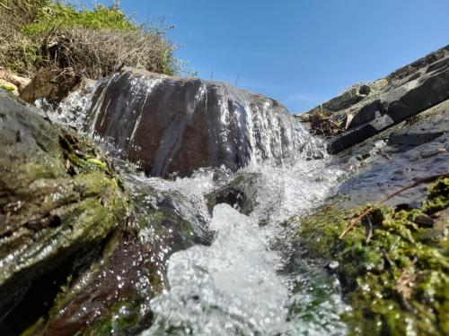 a waterfall on the side of a river at Herdade AMÁLIA RODRIGUES in Zambujeira do Mar
