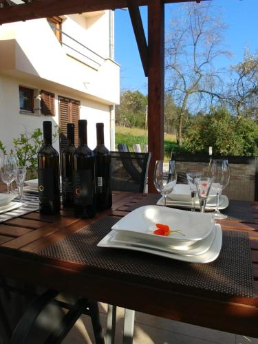 a table with wine glasses and a plate on it at Apartman Arena in Štrigova