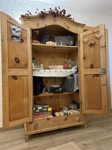 a wooden cabinet filled with lots of items at Bergwald Appartements Alpbach in Alpbach