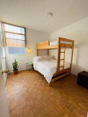 een slaapkamer met een stapelbed en een houten vloer bij Apartamento en el poblado in Medellín