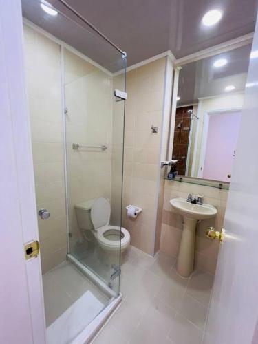 een badkamer met een douche, een toilet en een wastafel bij Apartamento en el poblado in Medellín