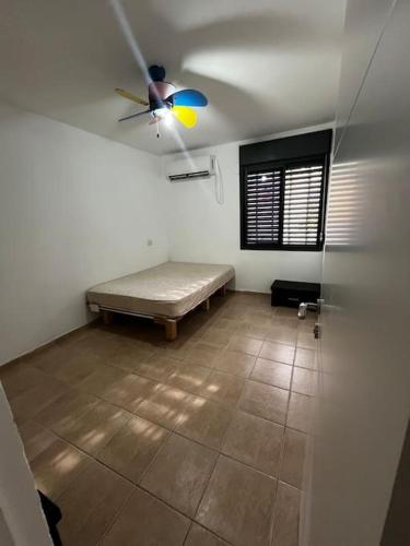 דירת הנופש שלכם في كريات شمونة: غرفة بها سرير ومروحة سقف