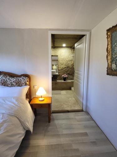 a bedroom with a bed and a table with a lamp at Airbnb: Vieilles Pierres et Rivière en Périgord in Couze-et-Saint-Front