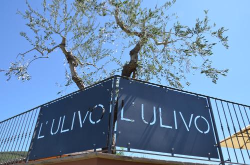 a sign for a villa with a tree behind it at Il Borgo Dell'Ulivo in Trevi