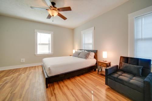 a bedroom with a bed and a couch and a ceiling fan at 3 Mi to Dtwn Walkable Apt in Cleveland! in Cleveland