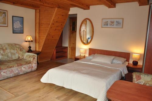 a bedroom with a bed and a couch at Central Łeba Suites in Łeba