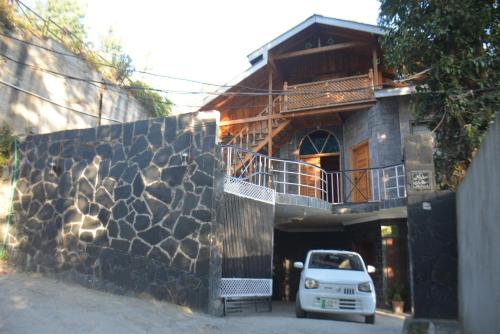 a white car parked in front of a building at Sardar House, Dunga Gali in Dunga Gali