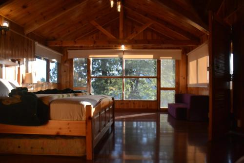 a bedroom with two beds and a large window at Sardar House, Dunga Gali in Dunga Gali