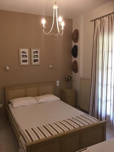 a bedroom with a bed and a chandelier at IVAS Pelion in Agios Ioannis Pelio