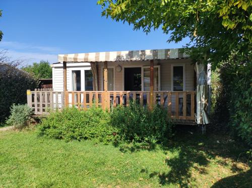 a small house with a porch in a yard at La Salicorne in Breuillet