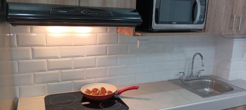 a kitchen counter with a bowl of food on a stove at La Posada De Don Jose in Flores