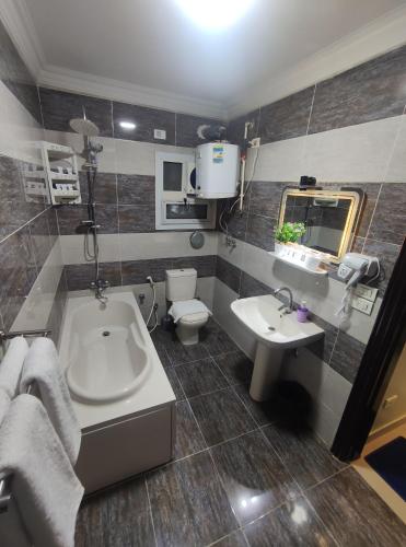 a bathroom with a tub and a sink and a toilet at Diamond Pyramids View Apartment in Cairo