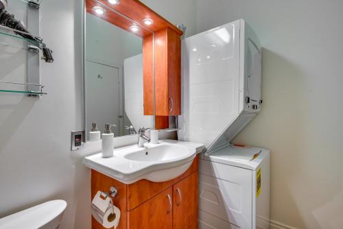 a bathroom with a sink and a toilet and a mirror at Downtown Los Angeles Condo with Shared Rooftop Pool! in Los Angeles