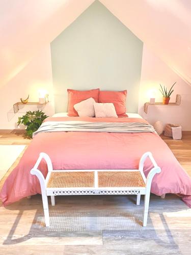 - une chambre avec un grand lit et des draps roses dans l'établissement Maison Mer & Jardin Ouistreham Riva-Bella, à Ouistreham
