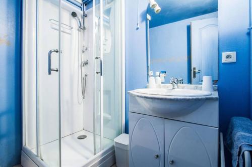 a blue bathroom with a sink and a shower at T2 au coeur de Blagnac- proche de tout- check in 24-24, parking in Blagnac