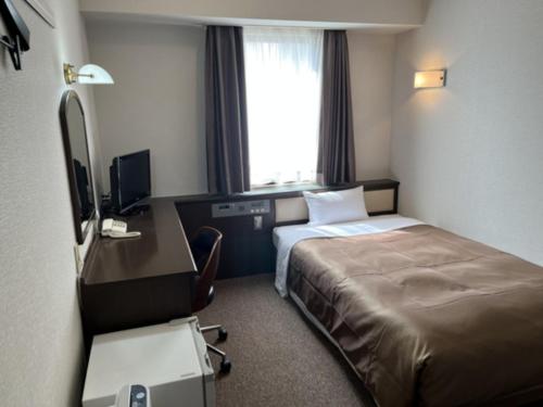 a hotel room with a bed and a desk with a computer at Kuwana Park Hotel - Vacation STAY 66862v in Kuwana