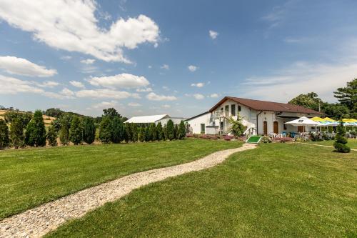 a large yard with a house and a grass field at Conacul Buzdugan 