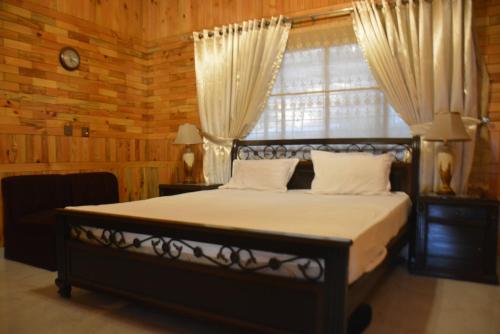a bedroom with a bed and a window with curtains at Sardar House, Dunga Gali in Dunga Gali
