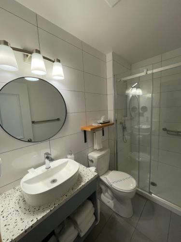 a bathroom with a sink and a toilet and a mirror at Auberge Marcel Gagnon in Sainte-Flavie