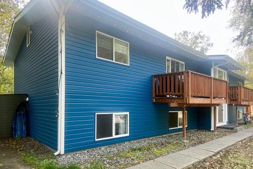 una casa azul con una terraza en un lado en The Bear Hug, en Eagle River