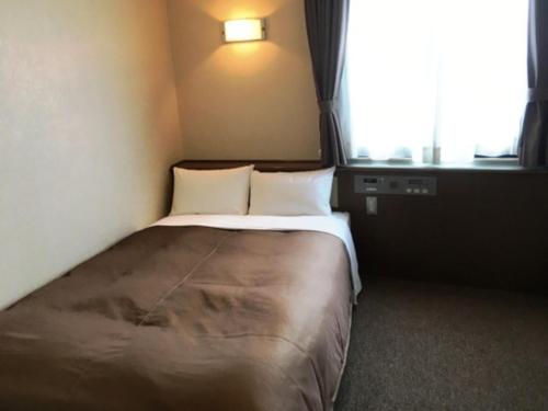a small bedroom with a bed with a window at Kuwana Park Hotel - Vacation STAY 66874v in Kuwana