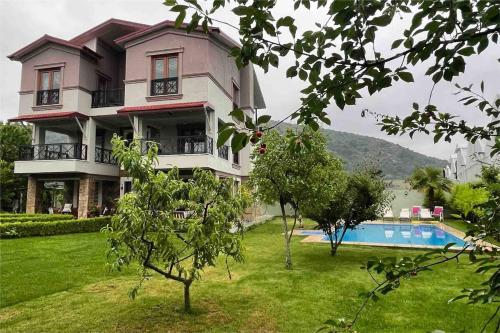 une grande maison avec une piscine en face de celle-ci dans l'établissement Bursa Iznik (Nicea) Doğa İçinde Eşsiz Çiftlik Evi, à İznik