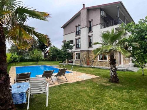 une villa avec une piscine en face d'une maison dans l'établissement Bursa Iznik (Nicea) Doğa İçinde Eşsiz Çiftlik Evi, à İznik