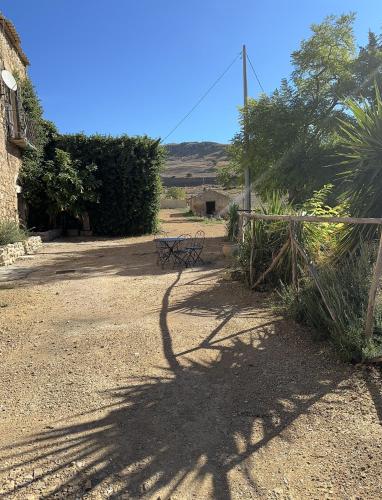 a bench sitting in the middle of a dirt road at Feudo Rosso di Cerami in Enna