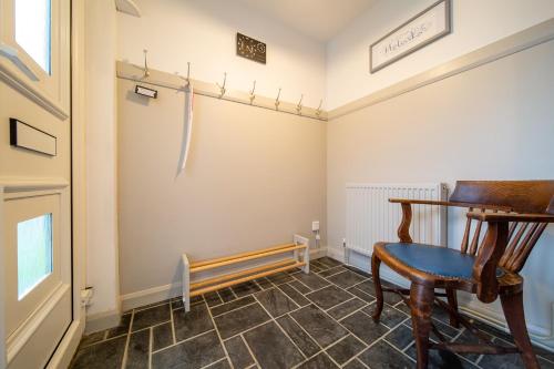 a room with a wooden chair and a table at Hebaska~Watergate Bay~3 Bedroom in Porth