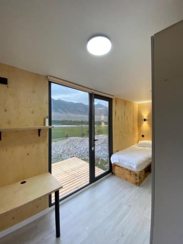 a bedroom with a bed and a large window at Panorama Glamping in Saty