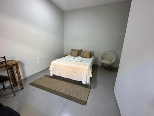 a small bedroom with a bed and a chair at Hotel Rosa Viva in Barretos