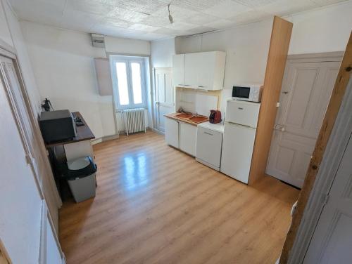 une cuisine avec des appareils blancs et un parquet dans l'établissement Charme et Authenticité, à Perreux