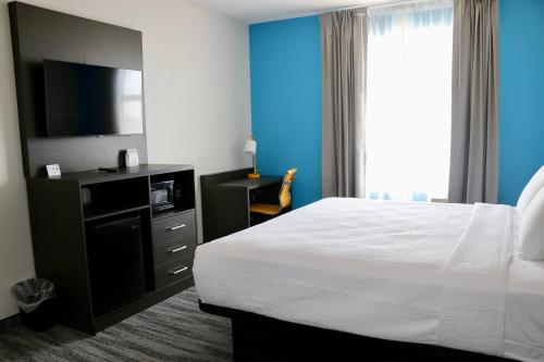 a hotel room with a bed and a flat screen tv at Quality Inn & Suites in Buda