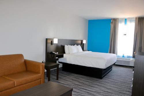 um quarto de hotel com uma cama e uma cadeira em Quality Inn & Suites em Buda