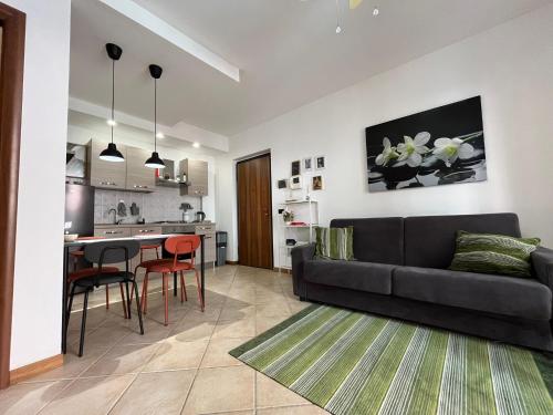 Appartamento Montebello في تيرني: غرفة معيشة مع أريكة سوداء ومطبخ