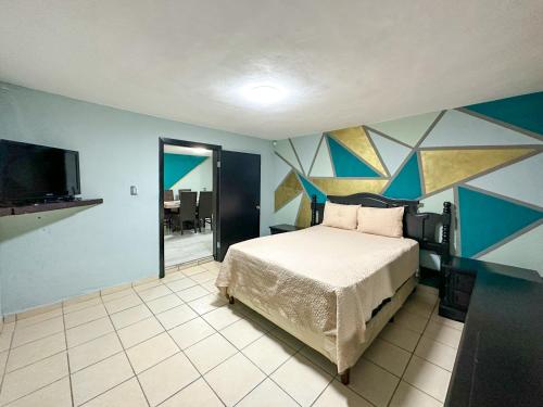 Schlafzimmer mit einem Bett und einem Flachbild-TV in der Unterkunft Town Gem Getaway 3 Bed House with Pool in Puerto Peñasco