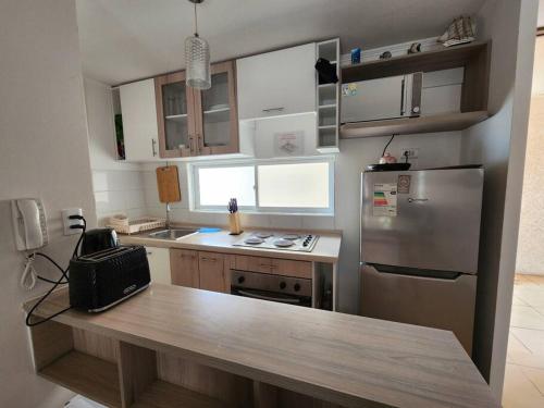 eine Küche mit einer Arbeitsplatte und einem Kühlschrank in der Unterkunft Departamento Los Molles, Exclusivo Frente a el Mar in Los Molles