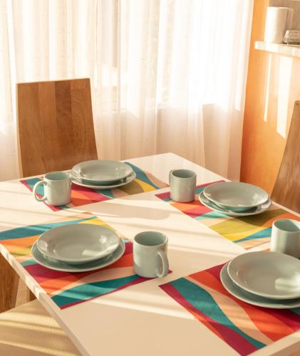 a table with plates and cups on a colorful table cloth at Apartamento Campestre in Fusagasuga