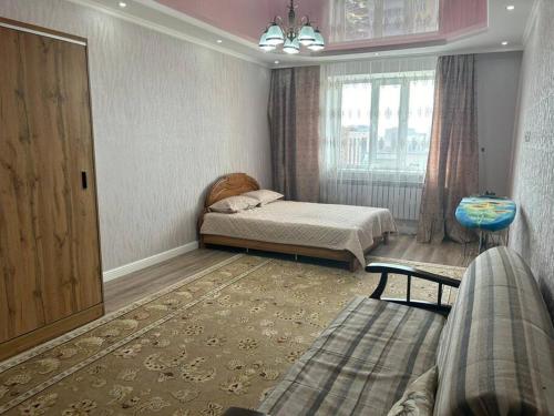 1 dormitorio con cama y ventana en Уютная квартира комфорт класса - 41, en Astana