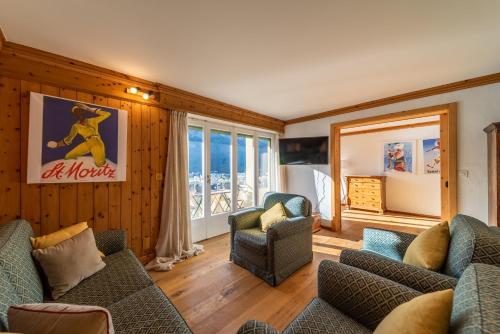 a living room with couches and chairs and a window at Chesa Bellavista - St. Moritz in St. Moritz