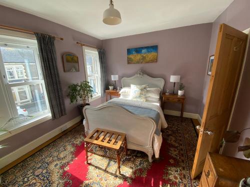 a bedroom with a bed and a chair and a window at Cardiff - Home from Home in Cardiff