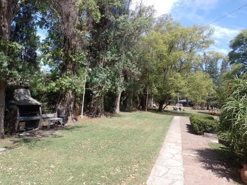 un parc avec un banc, des arbres et un chemin dans l'établissement Allá en el sur, à Ezeiza