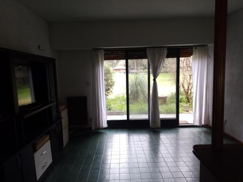 an empty living room with a large sliding glass door at Allá en el sur in Ezeiza