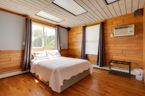 um quarto com uma cama, uma janela e uma ventoinha em Waterfront Barrington Estate with Hot Tub! em Barrington