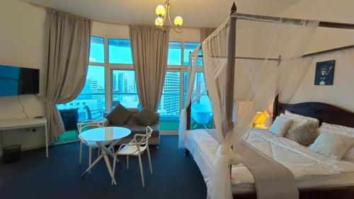 1 dormitorio con cama, escritorio y mesa en Near Atana Hotel en Dubái