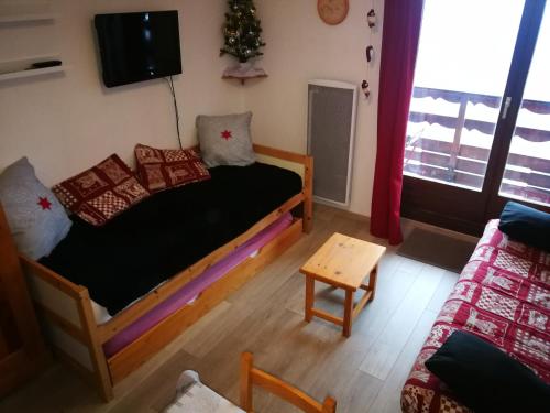 a room with a bed and a tv and a couch at T2, 5/6 pl, superbe vue, exp sud, douche italienne in LʼHuez
