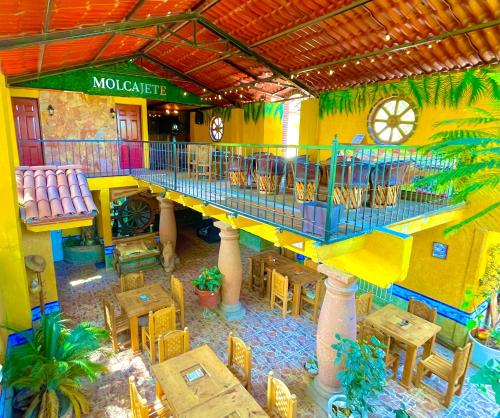 uma vista interior de um restaurante com mesas e um relógio em Posada Siete Nogales Tecozautla alojamiento con baño compartido em Tecozautla