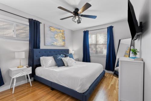 1 dormitorio con 1 cama azul y ventilador de techo en Stunning 4 BD Home near Tilles Park - JZ Vacation Rentals, en Richmond Heights