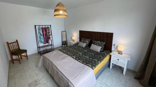 a bedroom with a large bed and a chair at Villa Estrella Polar in Tahiche